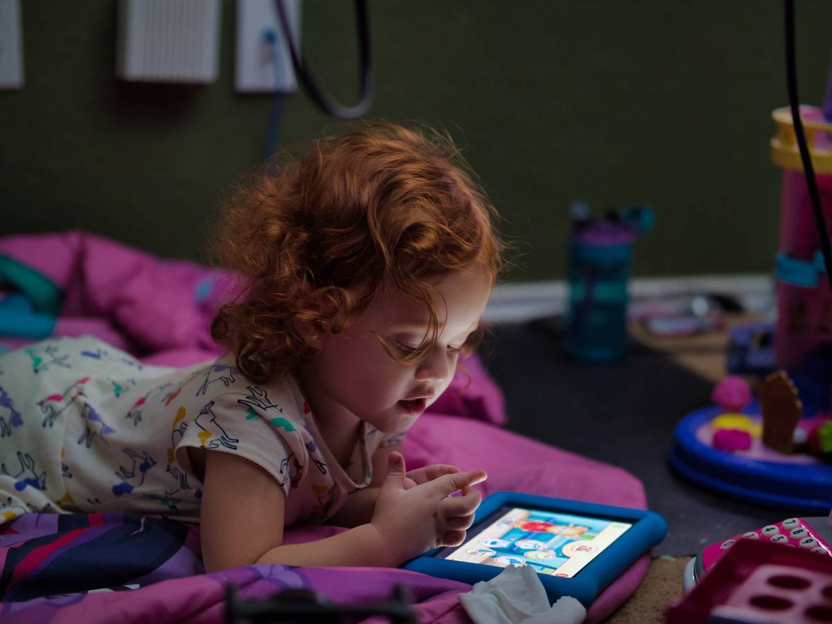Child using dyslexia learning app on tablet with colored overlay and text-to-speech enabled