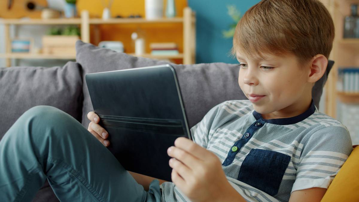 Child using a tablet with reading apps for dyslexic kids showing highlighted text and voice narration